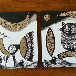 May include: Set of four black and white canvas paintings with gold accents. Each painting features a different stylised animal, including a bird, an owl, and two fish. The paintings are framed with a black border.