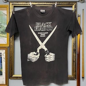 Könnte beinhalten: Ein anthrazitfarbenes Kurzarm-T-Shirt mit einer weißen Grafik von zwei Händen, die eine geöffnete Schere halten. Über der Schere steht der Text BLACK FLAG und darunter der Text EVERYTHING WENT BLACK. Das Shirt hat einen Rundhalsausschnitt.