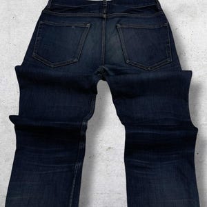 Op de afbeelding: Een witte keramische mok met een zwarte handgreep en de tekst "But First, Coffee" in een zwarte, vette letter. De mok is waarschijnlijk 325 ml groot, perfect voor een ochtenddrankje.