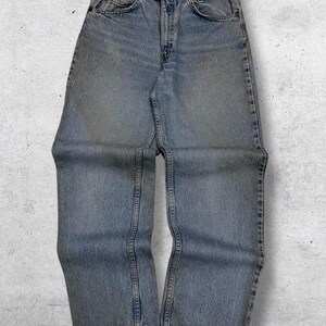 May include: Light blue denim jeans with a classic five-pocket design. The jeans have a straight leg cut and a faded wash, giving them a vintage look. The jeans are made of durable denim material and feature a button and zipper closure.