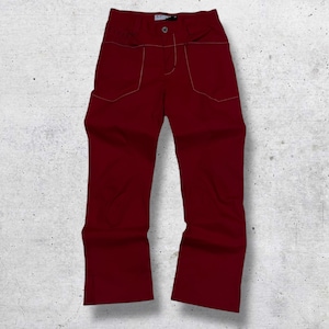 May include: A pair of burgundy pants with a button closure and two front pockets. The pants have light-colored stitching outlining the pockets and seams. The pants are displayed on a white and gray textured background.