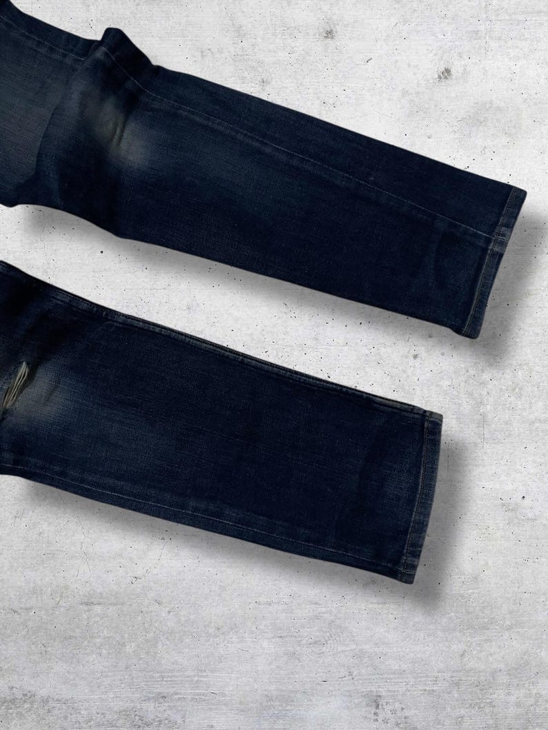 Op de afbeelding: Witte keramische mok met een zwarte handgreep en de tekst "But First, Coffee" in een handgeschreven stijl. Geschikt voor warme dranken, met een glanzende afwerking.