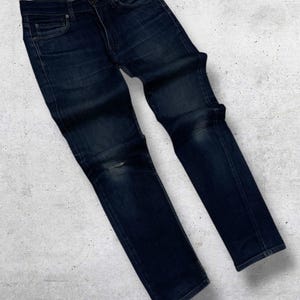 Op de afbeelding: Een set van drie keramische mokken met een gespikkelde, matte afwerking. De mokken zijn in cr&egrave;me, lichtgrijs en donkergrijs. Elke mok heeft een eenvoudig, minimalistisch ontwerp.