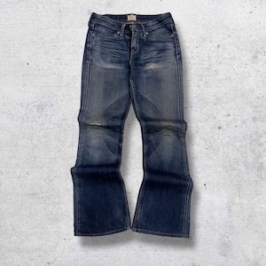 May include: Faded blue denim jeans with a slight flare at the bottom. The jeans have a worn appearance with distressed areas on the knees and thighs. They feature a classic five-pocket design and a button and zipper closure.