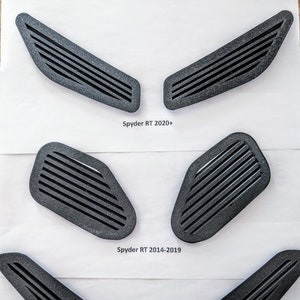 May include: Three sets of black plastic air vents for a Spyder motorcycle. The top set is labelled "Spyder RT 2020+", the middle set is labelled "Spyder RT 2014-2019", and the bottom set is labelled "Spyder F3".