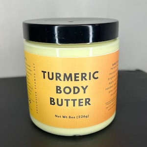 May include: A yellow jar of turmeric body butter with a black lid. The jar is labeled "Turmeric Body Butter" and "Net Wt 8oz (226g)".