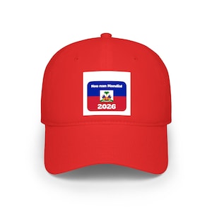 May include: A bright red baseball cap featuring a white square with the Haitian flag and the text "Hou nan Mondial" above "2026". The cap is made of a durable fabric and has a curved brim.