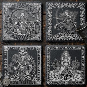 May include: Set of four square black slate coasters with engraved Viking warrior designs. Each coaster features a different image of a warrior with intricate border patterns. Designs include a warrior with a sword, a bow and arrow, an axe, and runes.