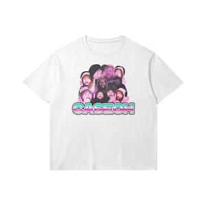 Puede incluir: Camiseta blanca con un gráfico de un grupo de caras de personas con la palabra "CASEOH" en letras rosa y azul.