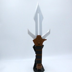 May include: A white and brown dagger with a stylized design. The blade is white with a central groove, and the handle features brown and black sections. The dagger is displayed on a black stand.