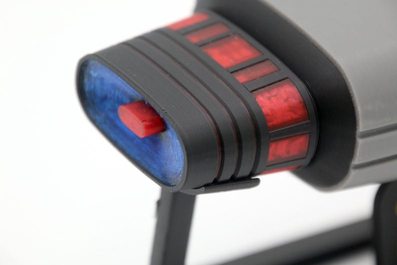 K&ouml;nnte beinhalten: Nahaufnahme eines schwarzen und grauen Raumschiffmodells mit roten und blauen Details. Das Modell verf&uuml;gt &uuml;ber ein detailliertes Cockpit und ein elegantes Design.
