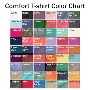 May include: A color chart for Comfort T-shirts, featuring a grid of various colors. The chart includes shades like white, black, berry, blossom, blue jean, and blue spruce. Each color is labeled with its name, offering a comprehensive palette.
