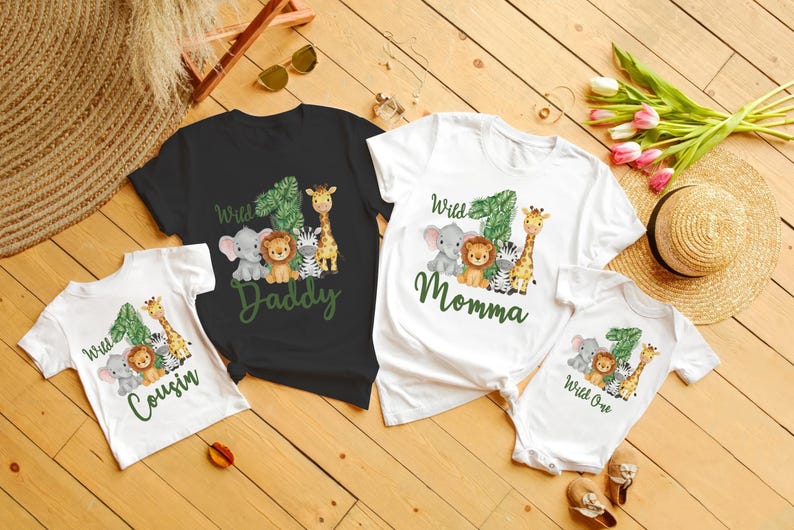Pu&ograve; includere: Una collezione di magliette familiari abbinate e un body a tema giungla. Le magliette sono nere e bianche, e il body &egrave; bianco. Ogni maglietta presenta il numero uno, animali della giungla e le parole "Daddy", "Momma", "Cousin" e "Wild One".