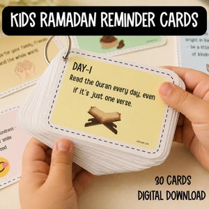 May include: A stack of rectangular reminder cards held together by a metal ring. The top card is pale yellow with a dashed border, featuring the text 'DAY-1 Read the Quran every day, even if it's just one verse' and an illustration of an open book.