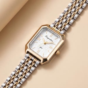 May include: A rectangular wristwatch with a gold-toned bezel and a silver and gold-toned band. The watch face is white with gold-toned hands and the text "Xinyunhou". The band is made of interlocking links.