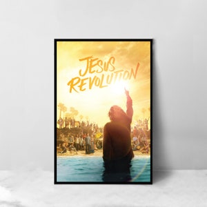 May include: A poster with a yellow and orange sunset background featuring a person with their arm raised in the air. The text "JESUS REVOLUTION" is written in black and yellow paint across the top of the poster.