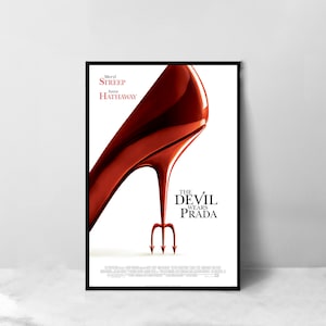 Könnte beinhalten: Filmplakat für "Der Teufel trägt Prada" mit einem roten High-Heel-Schuh mit einer Teufelsgabel im Absatz. Das Plakat zeigt auch die Namen der Stars, Meryl Streep und Anne Hathaway.