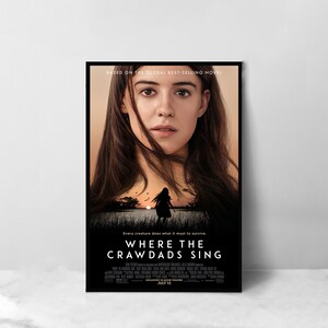 Op de afbeelding: Filmplakat voor de film "Waar de Kreeften Zingen" gebaseerd op de gelijknamige roman. De poster toont een jonge vrouw met lang bruin haar die rechtstreeks naar de kijker kijkt. De achtergrond is een zonsondergang boven een moeras met het silhouet van een jong meisje dat van de kijker afloopt.