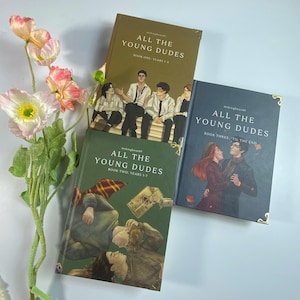 May include: A white ceramic mug with a black handle and the text "But First, Coffee" in a black, bold font. The mug is on a white surface.