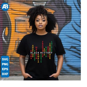 May include: Black t-shirt with a word search design featuring the words "Black History" and other related terms. The words are arranged in a grid pattern and are coloured in red, green, and yellow.
