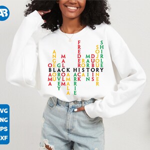 May include: White sweatshirt with a black and green word puzzle design that reads "BLACK HISTORY" with the letters forming a pyramid shape.