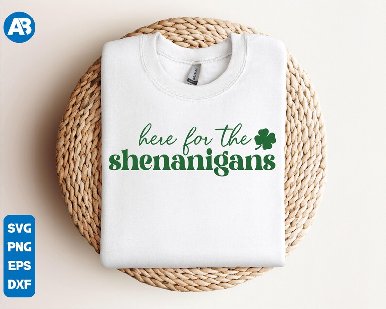 May include: White sweatshirt with the text "here for the shenanigans" in green lettering and a green shamrock.