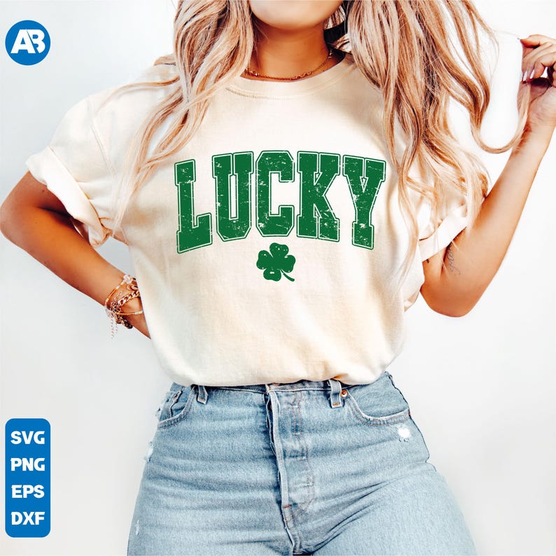 May include: A white t-shirt with the word "LUCKY" printed in green with a distressed look. A green four-leaf clover is below the word.