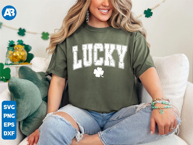 May include: A green t-shirt with the word "LUCKY" in white letters and a white four-leaf clover. The shirt is being worn by a person with long brown hair.