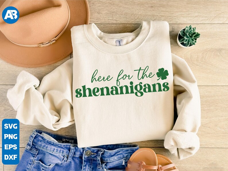 May include: A cream-colored sweatshirt with the text "here for the shenanigans" in green lettering and a green shamrock.