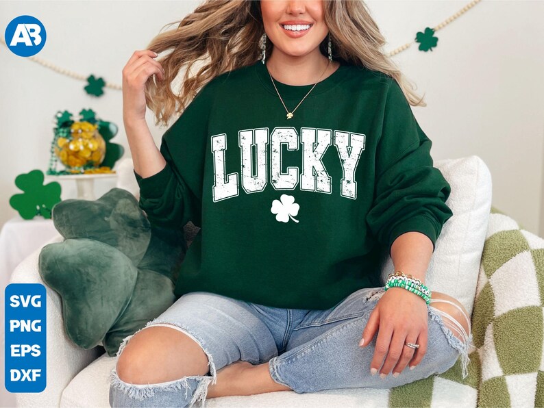 May include: A green sweatshirt with the word "LUCKY" in white letters with a distressed look. A white four-leaf clover is below the word.
