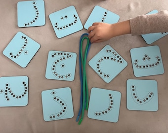 May include: Light blue wooden educational toy featuring Arabic letters with pre-drilled holes for lacing. Includes blue and green laces. The letters are arranged on a light gray surface, designed for early learning and fine motor skills.