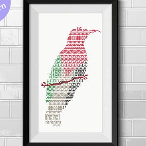 May include: Framed art print featuring a stylized bird design in cross-stitch style. The bird is perched on a branch, rendered in red, green, and gray geometric patterns against a white background. The artwork is framed in a black border.