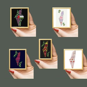 May include: Five framed cross-stitch artworks featuring the map of Palestine. Each piece is in a gold frame and depicts the map with various designs, including floral patterns, the Palestinian flag, and traditional motifs. The backgrounds vary from black to white.
