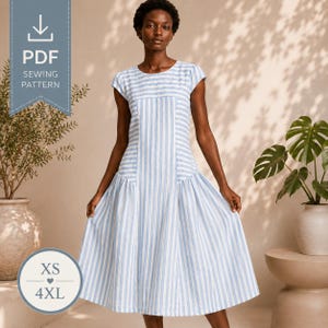 Pode incluir: Um vestido de comprimento midi com um padrão de riscas verticais em azul claro e branco, decote redondo e mangas curtas. O corpete tem riscas verticais, enquanto a saia transita para uma silhueta rodada com riscas verticais.