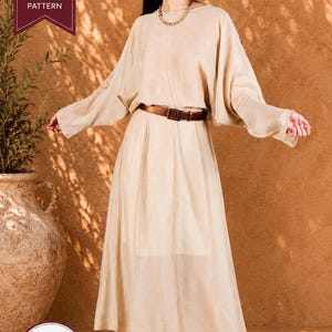May include: A beige two-piece outfit consisting of a long-sleeved top with wide sleeves and a matching floor-length skirt. The ensemble is cinched at the waist with a brown leather belt. A banner in the corner reads PDF SEWING PATTERN and SIZES XS-XXXL.