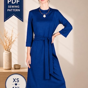 Puede incluir: Un vestido midi azul real con cuello alto, mangas tres cuartos y un cinturón de tela a juego en la cintura. El producto digital incluye un patrón de costura en PDF disponible en tallas que van desde la XS hasta la 4XL.