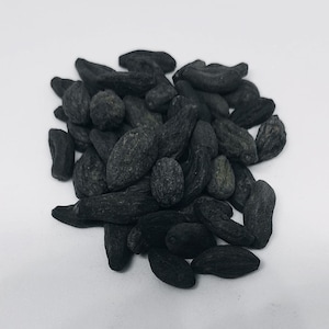 May include: A pile of black garlic cloves, a fermented garlic product with a sweet and savory flavor.