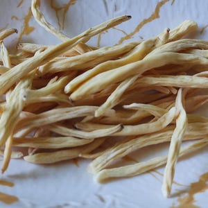 May include: A bowl of dried, light brown, thin, and long pieces of a plant root.