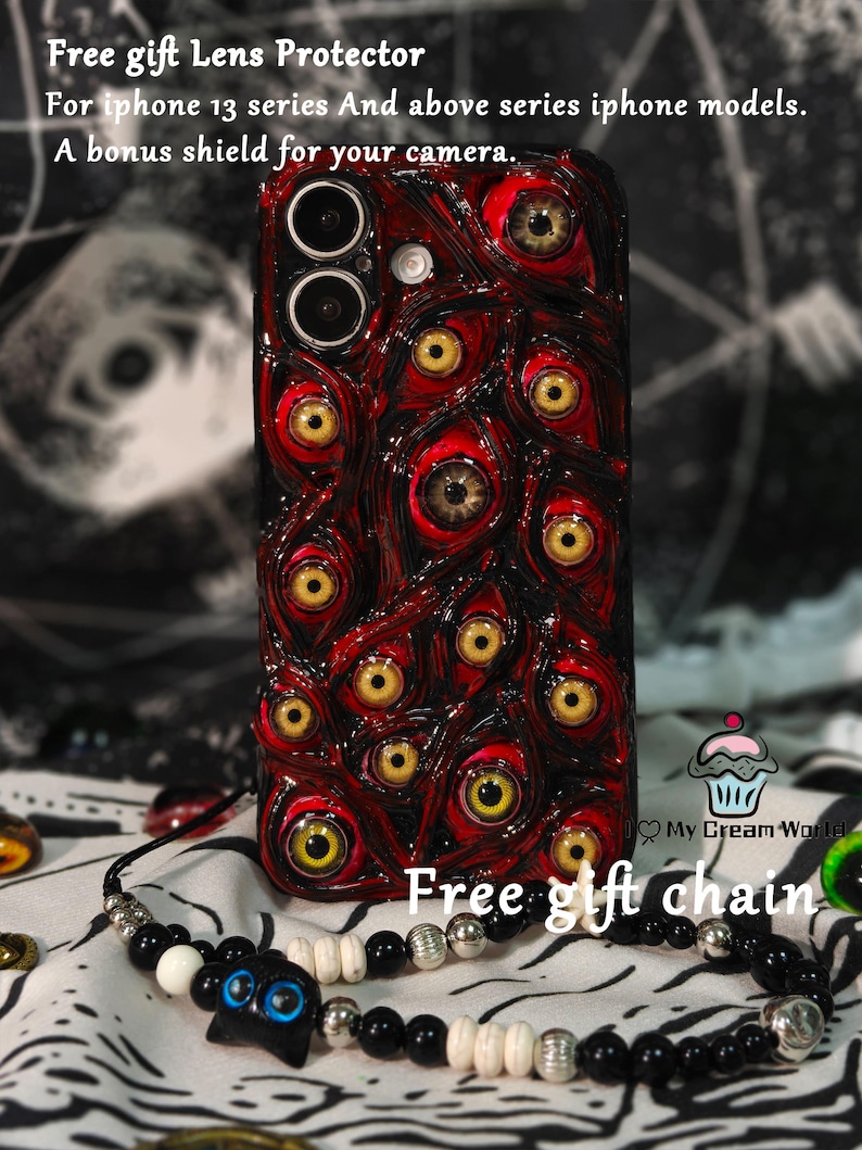 May include: A red and black phone case with a pattern of multiple eyes, with yellow irises and brown pupils. The case is for iPhone 13 series and above models. A black and white beaded necklace is also visible.