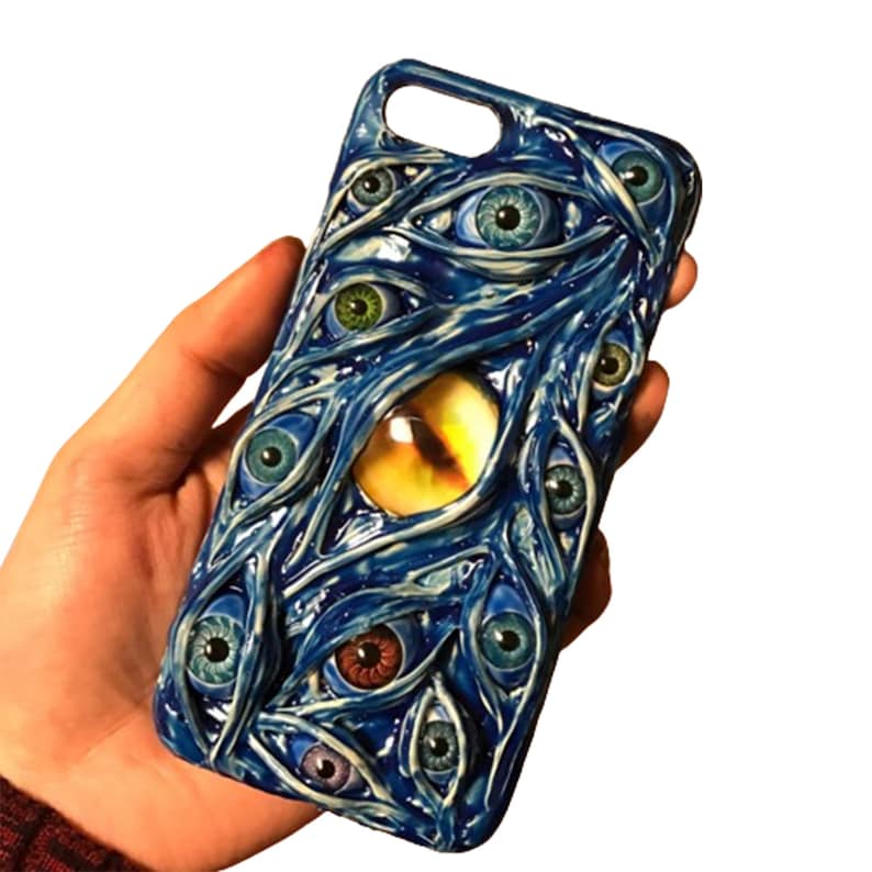 May include: A blue phone case with a design of multiple eyes, some with yellow, green, blue, and red irises. The eyes are surrounded by blue and white veins.