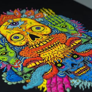 May include: A colorful skull with a third eye and a beard surrounded by other colorful creatures with eyes and teeth. The background is black.