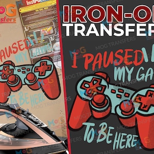 以下が含まれることがあります： 「I Paused My Game To Be Here」というテキストが入った、赤と青のビデオゲームコントローラーが描かれたアイロン転写デザインです。