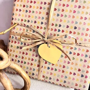 Gift wrapped in recycled heart print paper with natural ribbon and yellow heart tag