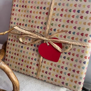 Gift wrapped in recycled heart print paper with natural ribbon and red heart tag