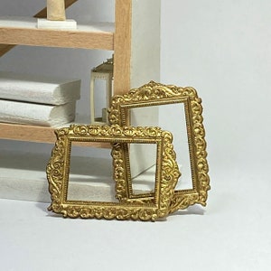 May include: Two ornate gold picture frames with intricate details. The frames are empty and ready to display your favorite photos or artwork.