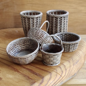 May include: A set of five woven baskets in various sizes and shapes. The baskets are made of natural materials and have a rustic, vintage look.