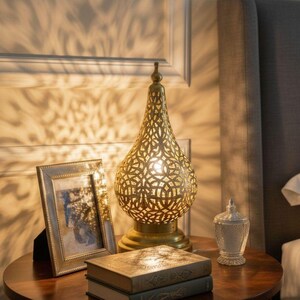 Ornate engraved brass lamp with soft ambient lighting for cozy interior design.