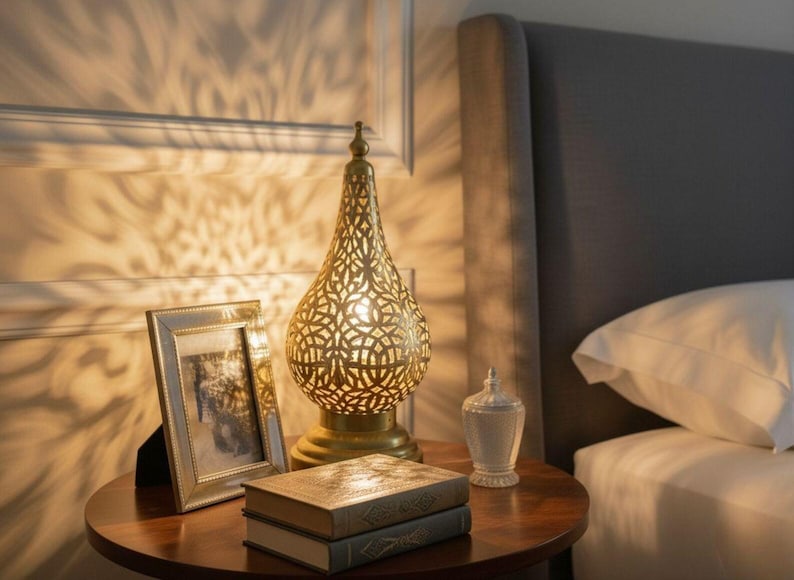 Handmade Moroccan brass lamp featuring intricate vintage detailing, perfect for antique bedside table decor or boho living spaces. This artisan-crafted brass light adds warm ambient glow and authentic Moroccan charm to any rustic or Arabic-inspired home. Ideal gift for lovers of unique, handcrafted lighting.