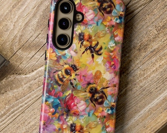 May include: A phone case with a colorful floral and bee design. The case has a black border and a camera cutout. The design features a variety of flowers and bees in shades of pink, yellow, blue, and green.