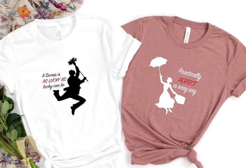 May include: Two t-shirts with a Mary Poppins theme. The white t-shirt has a black silhouette of Bert sweeping with the text "A Sweep is as Lucky as Lucky can be". The pink t-shirt has a white silhouette of Mary Poppins holding an umbrella with the text "Practically Perfect in every way".